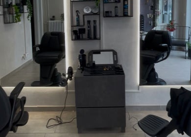 Interno moderno di Hair Barber Family a Poirino, Piemonte, IT con poltrone e specchi sofisticati.