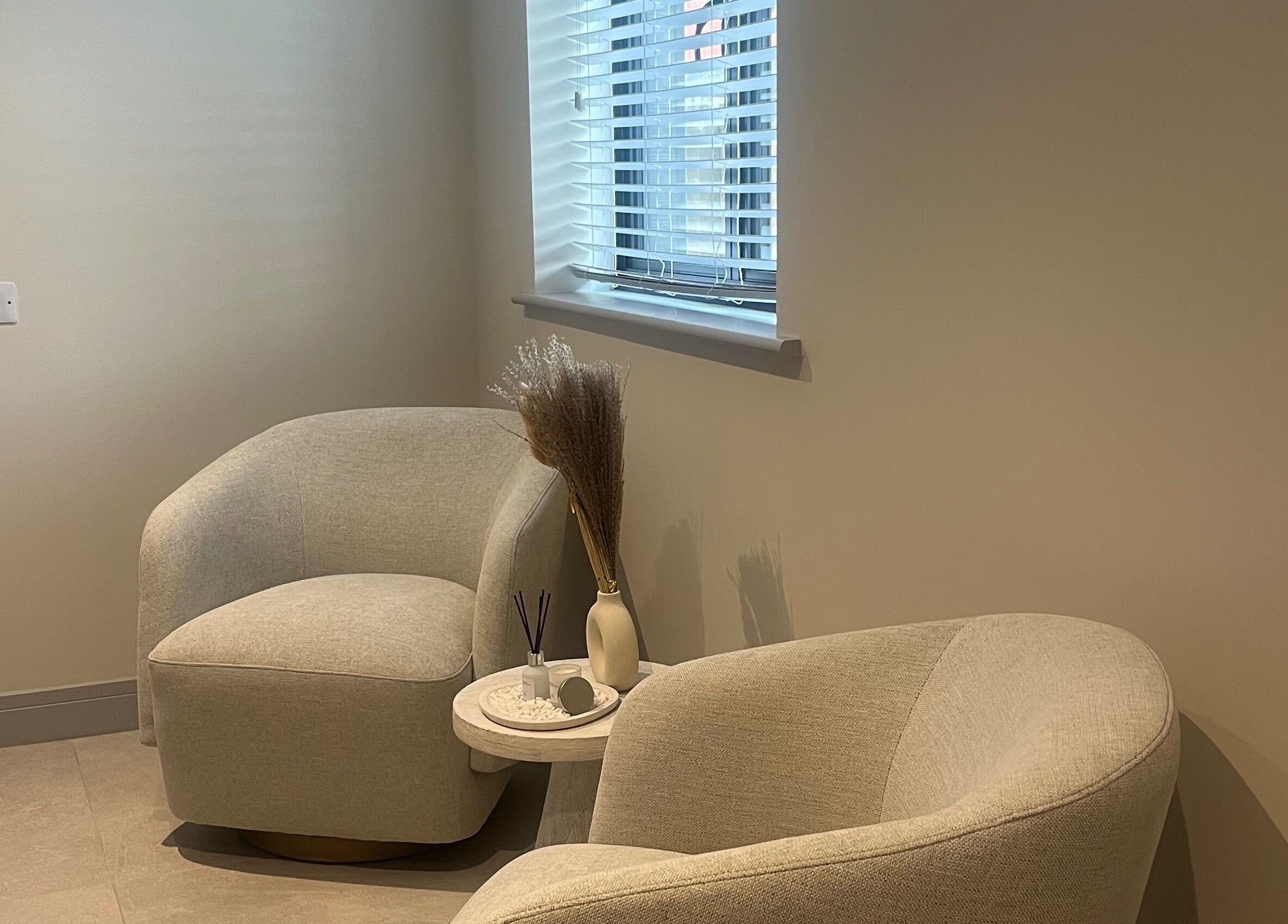 Relaxing seating area at Skin Space, Stevenage, England, GB, featuring soft chairs and minimalist decor.