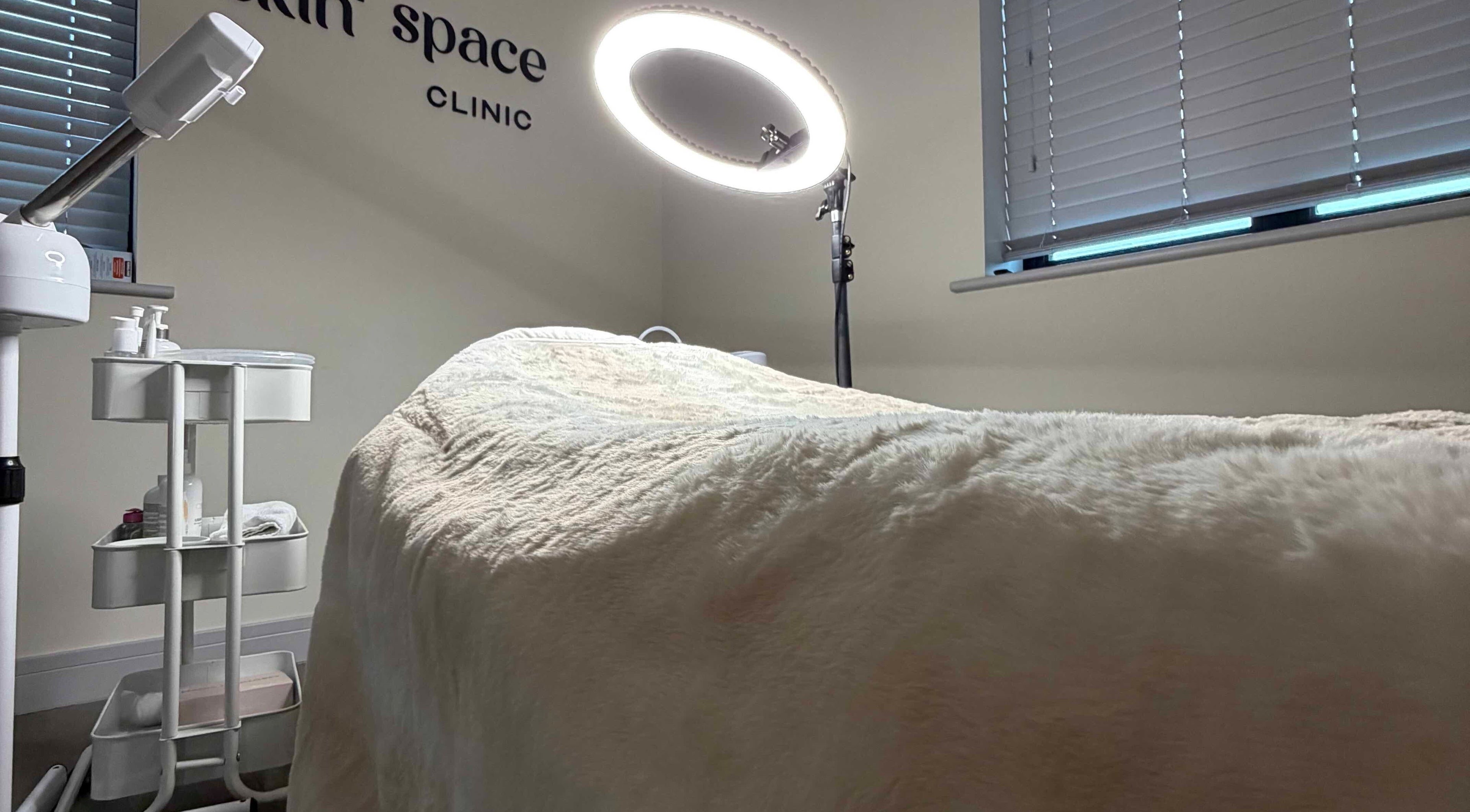 Cozy treatment room at Skin Space, Stevenage, England, GB with plush bed, ring light, and skincare essentials.