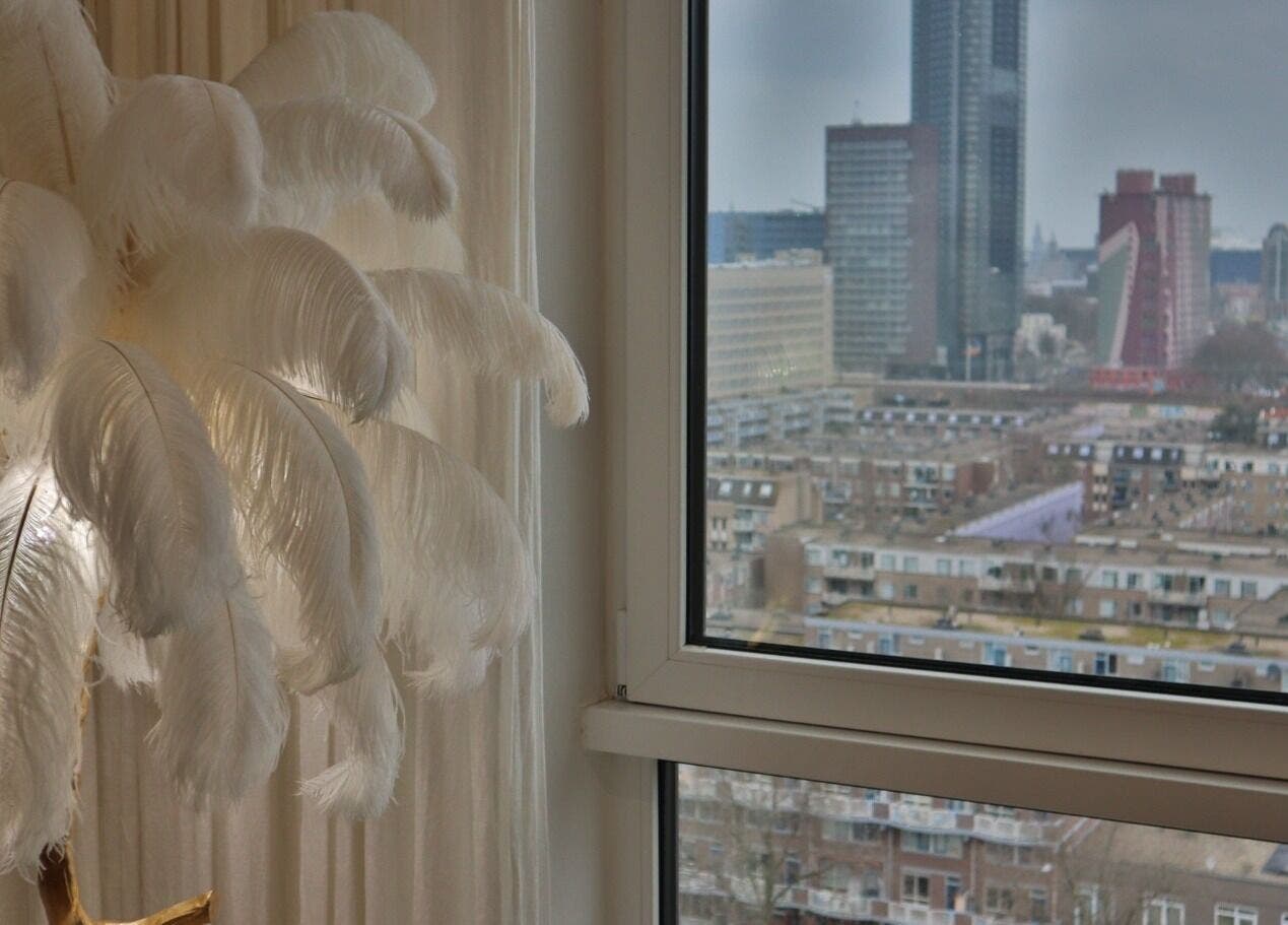 Elegant wit gevederde lamp bij Safferonails met uitzicht op Den Haag, Zuid-Holland, NL skyline.