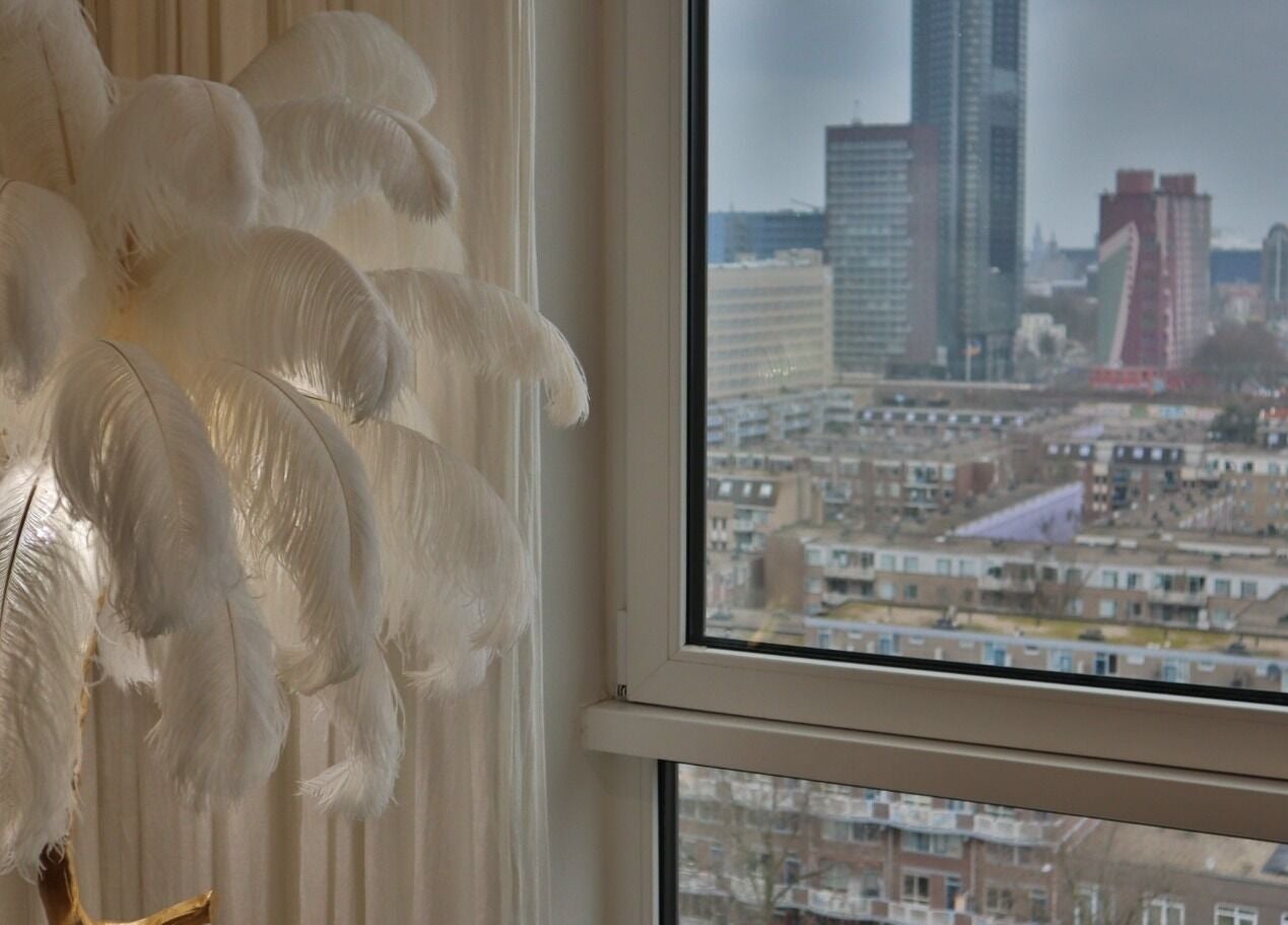 Elegant wit gevederde lamp bij Safferonails met uitzicht op Den Haag, Zuid-Holland, NL skyline.