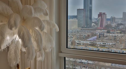 Elegant wit gevederde lamp bij Safferonails met uitzicht op Den Haag, Zuid-Holland, NL skyline.