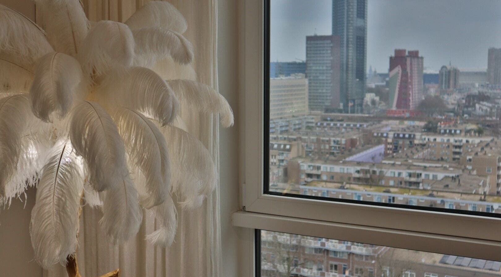 Elegant wit gevederde lamp bij Safferonails met uitzicht op Den Haag, Zuid-Holland, NL skyline.