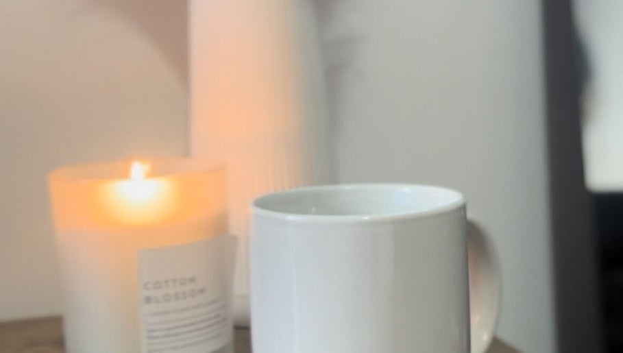 Lit candle and mug at Remi Room, Fareham, England, GB create a cozy and calming ambiance.