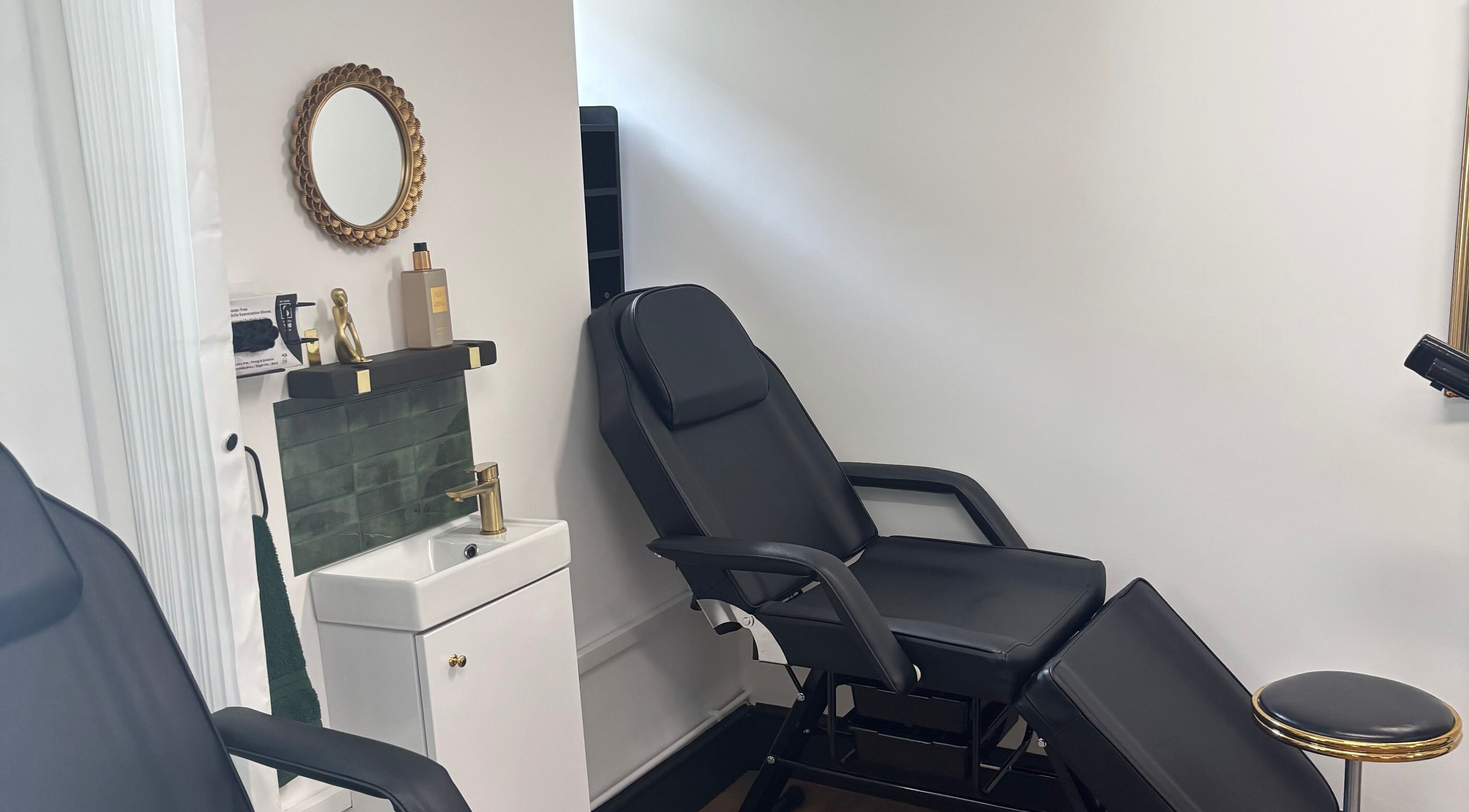Luxe treatment room at Lumière by Brooke-Leigh, Chipping Sodbury, England, GB. Stylish black chair and chic decor.