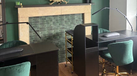 Elegant nail station at Lumière by Brooke-Leigh in Chipping Sodbury, England, GB, with green chairs and gold accents.