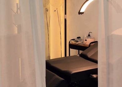 Interior sereno en Velet Beauty Studio, Oranjestad, AW, con cama de tratamiento y luz acogedora.