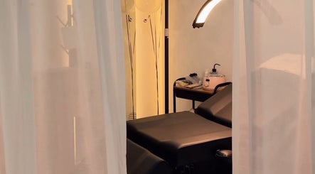 Interior sereno en Velet Beauty Studio, Oranjestad, AW, con cama de tratamiento y luz acogedora.