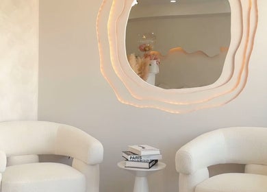 Espacio elegante en Velet Beauty Studio, Oranjestad, AW, con sillones blancos y espejo decorativo.