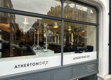 Вид на салон ATHERTONCOX с улицы в Лондоне, Англия. Видна работа Виктории, стилиста по волосам.