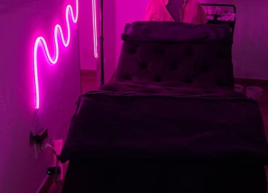 Sala de masajes con luz neón en Bloom Studio, Rosario, Santa Fe, AR. Ambiente acogedor para relajación.
