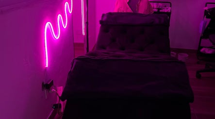 Sala de masajes con luz neón en Bloom Studio, Rosario, Santa Fe, AR. Ambiente acogedor para relajación.