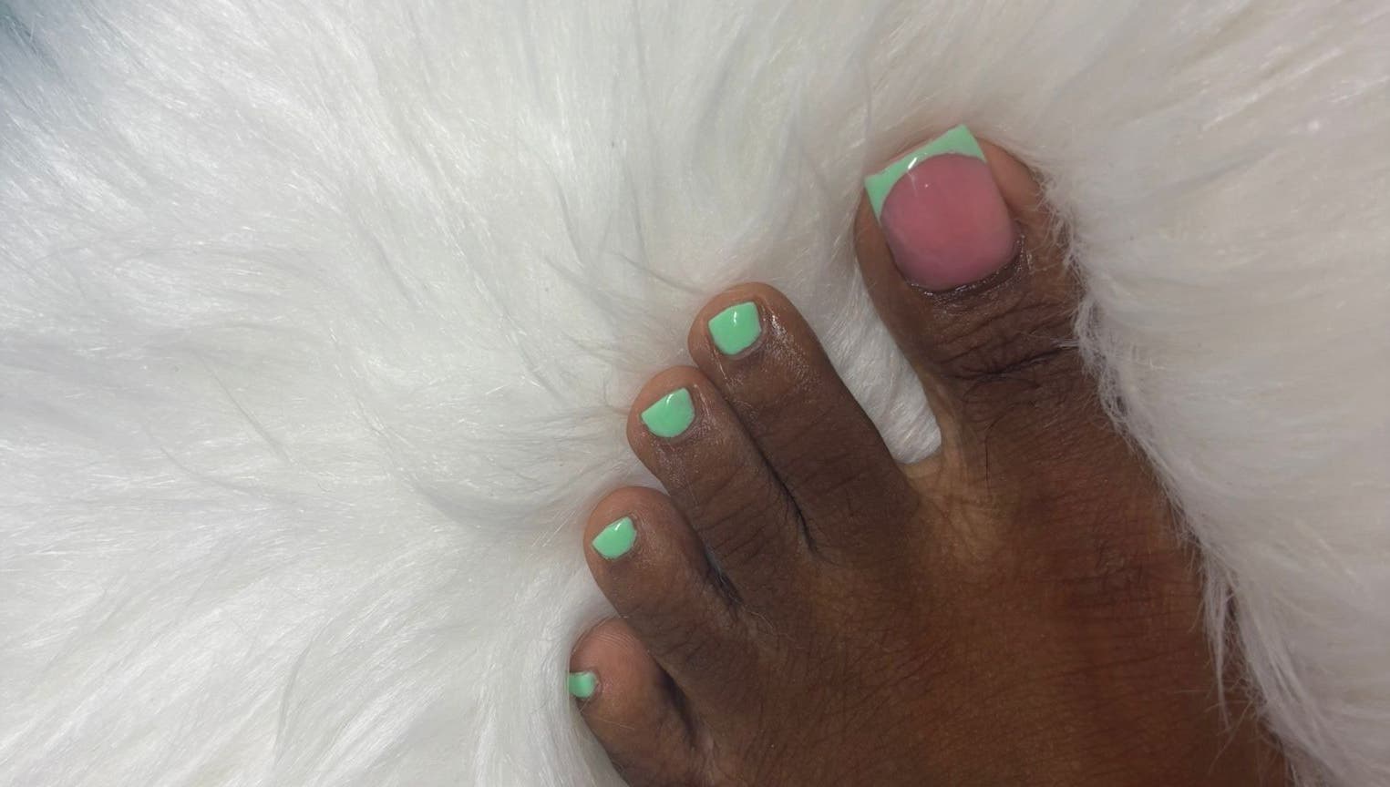 Stylish mint green pedicure from The Nail Candy at Cave Hill, Saint Lucy, BB on plush white fur.