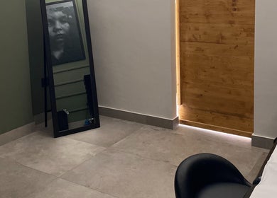 Interno elegante di Iago Tattoo a Marano Di Napoli, Campania, IT, con specchio e porta in legno.