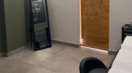 Interno elegante di Iago Tattoo a Marano Di Napoli, Campania, IT, con specchio e porta in legno.