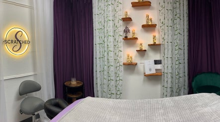 Cozy treatment room at Scratched in Modesto, California, US with candles and soothing decor.