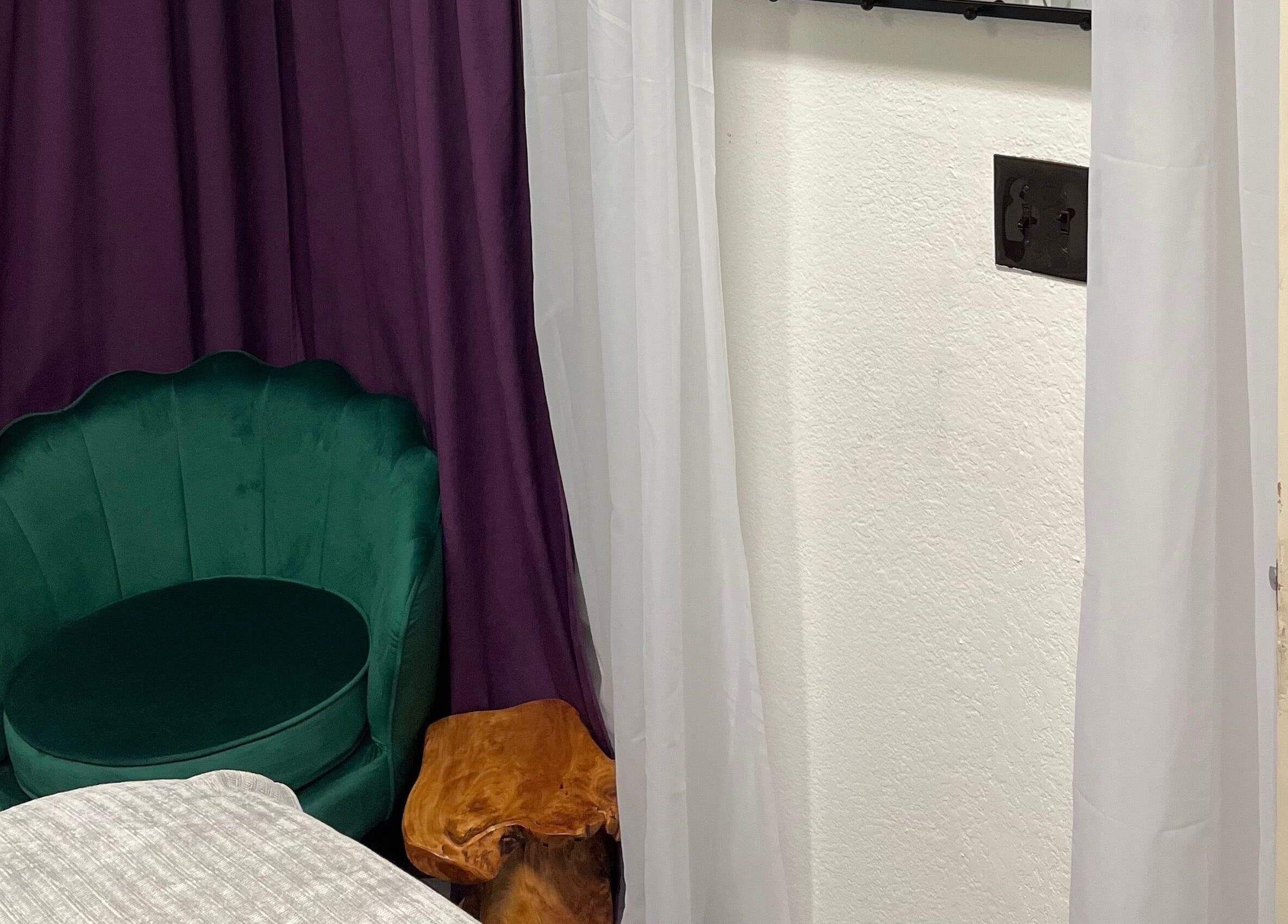 Elegant green chair in a serene room at Scratched, Modesto, California, US, offering a tranquil wellness experience.