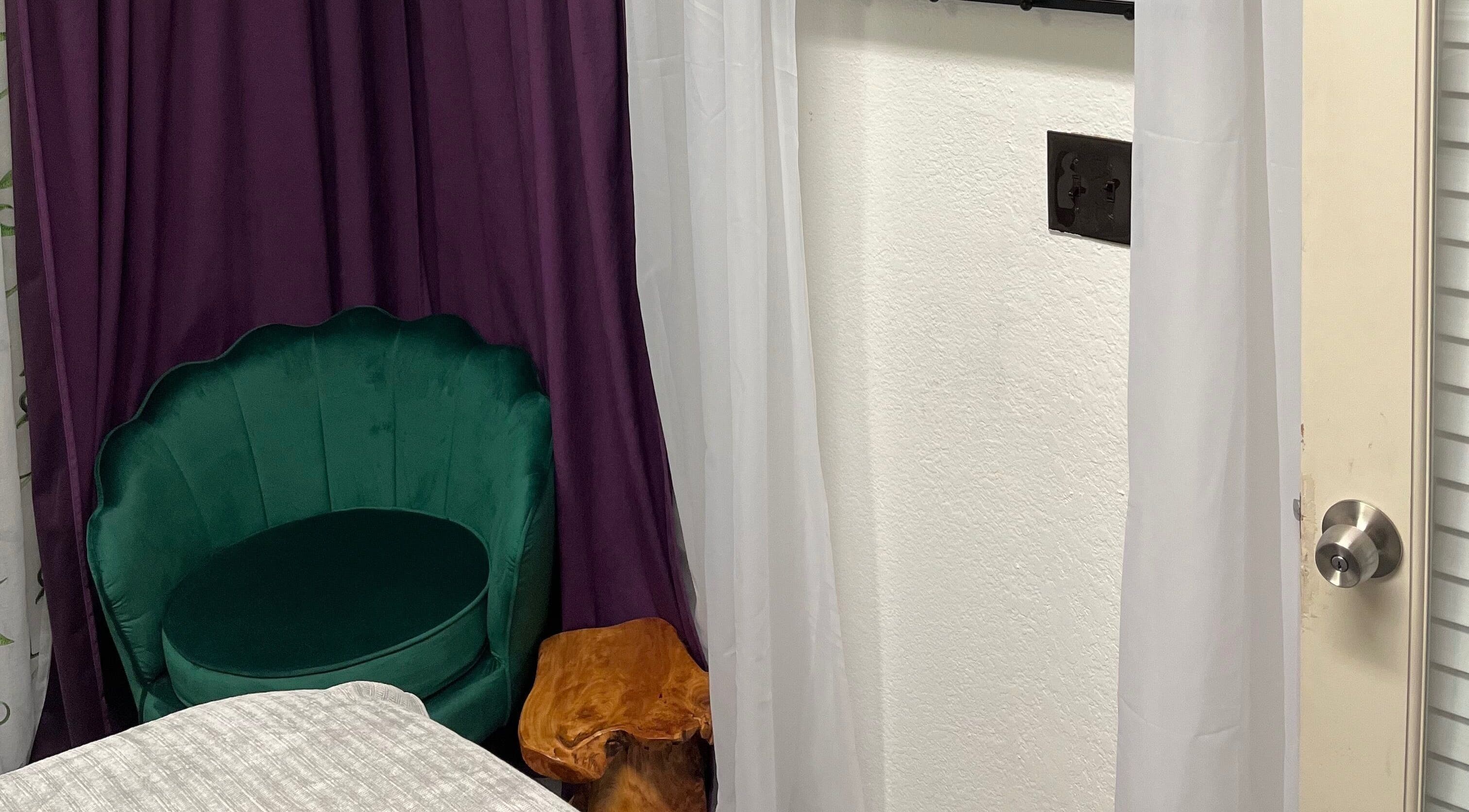 Elegant green chair in a serene room at Scratched, Modesto, California, US, offering a tranquil wellness experience.