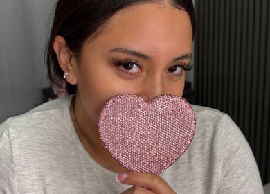 Woman holding a pink heart at Jiribeauty in Rockwall, Texas, US, showcasing eye-catching lashes.