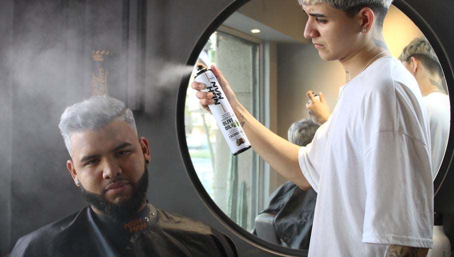Estilista aplicando spray en cabello de cliente en Tony Barber, Santiago, Región Metropolitana, CL.