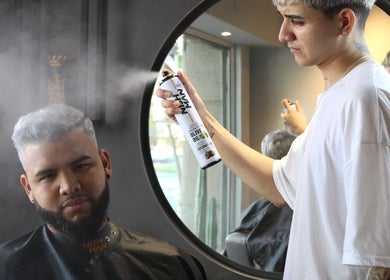 Estilista aplicando spray en cabello de cliente en Tony Barber, Santiago, Región Metropolitana, CL.