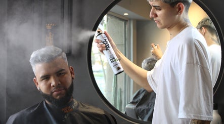 Estilista aplicando spray en cabello de cliente en Tony Barber, Santiago, Región Metropolitana, CL.