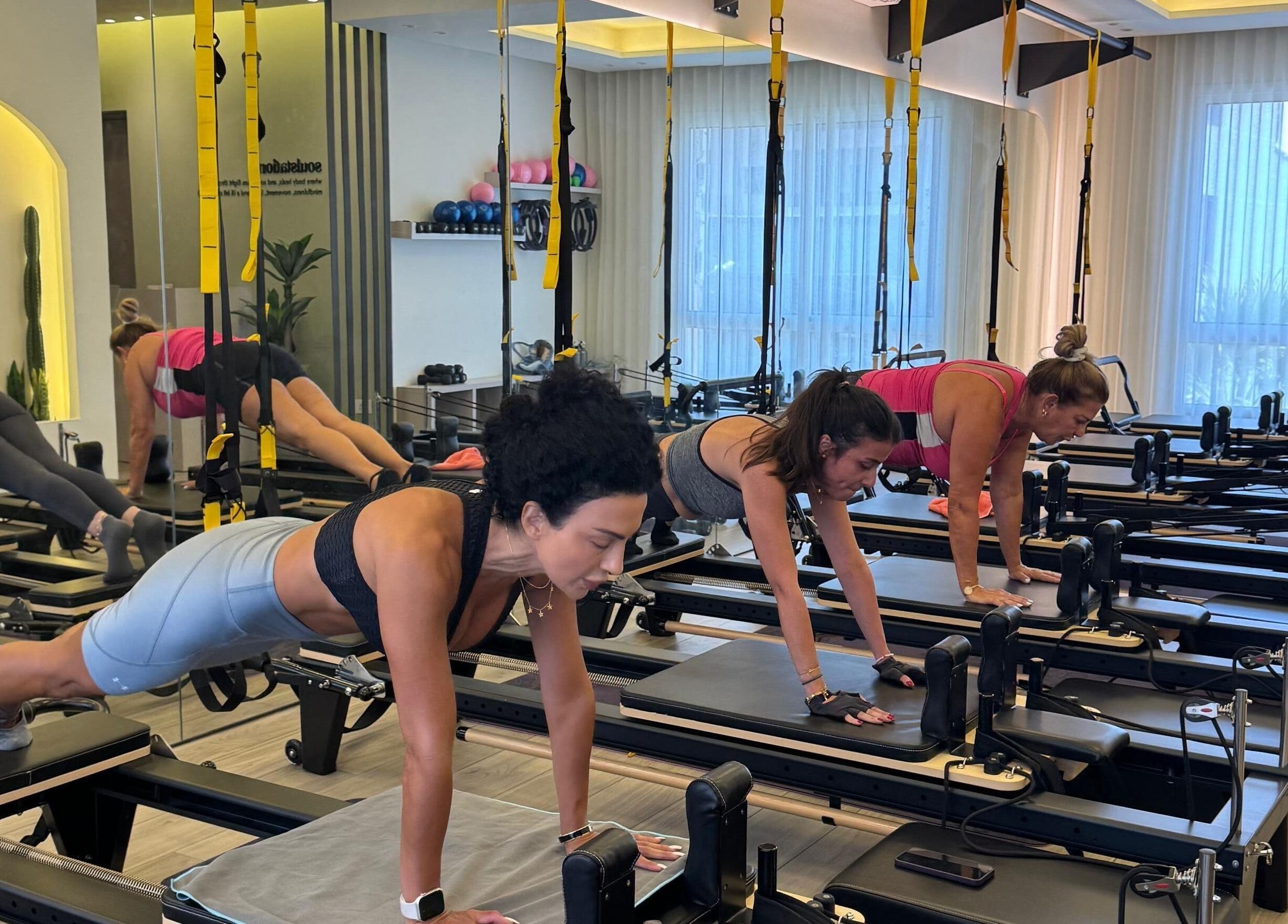 Women practicing Pilates at SoulStation Pilates, Zalqa, Mount Lebanon Governorate, LB, in a bright studio.