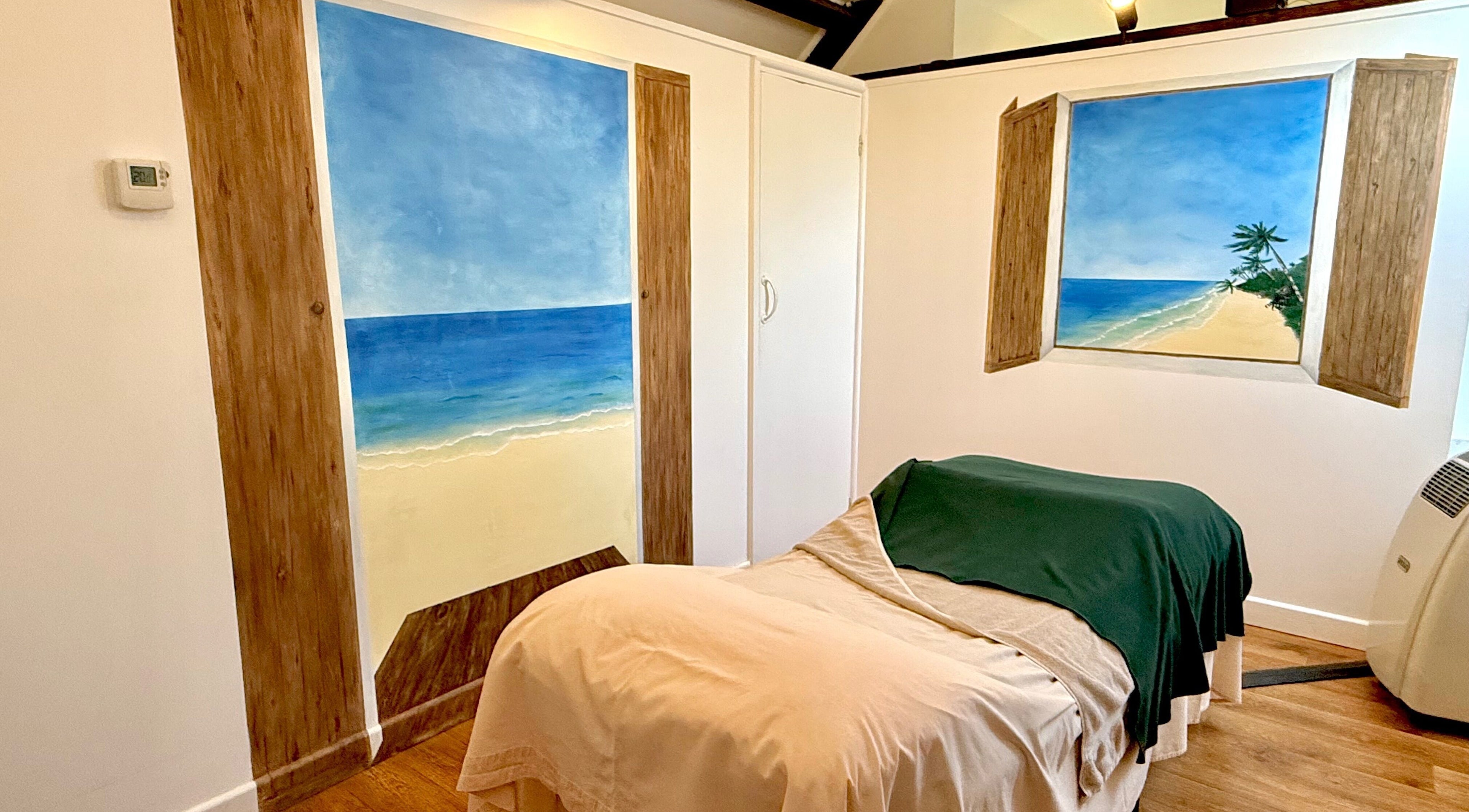 Relaxing spa room at All Elements in Wellington, England, GB, featuring beach-themed murals and serene decor.