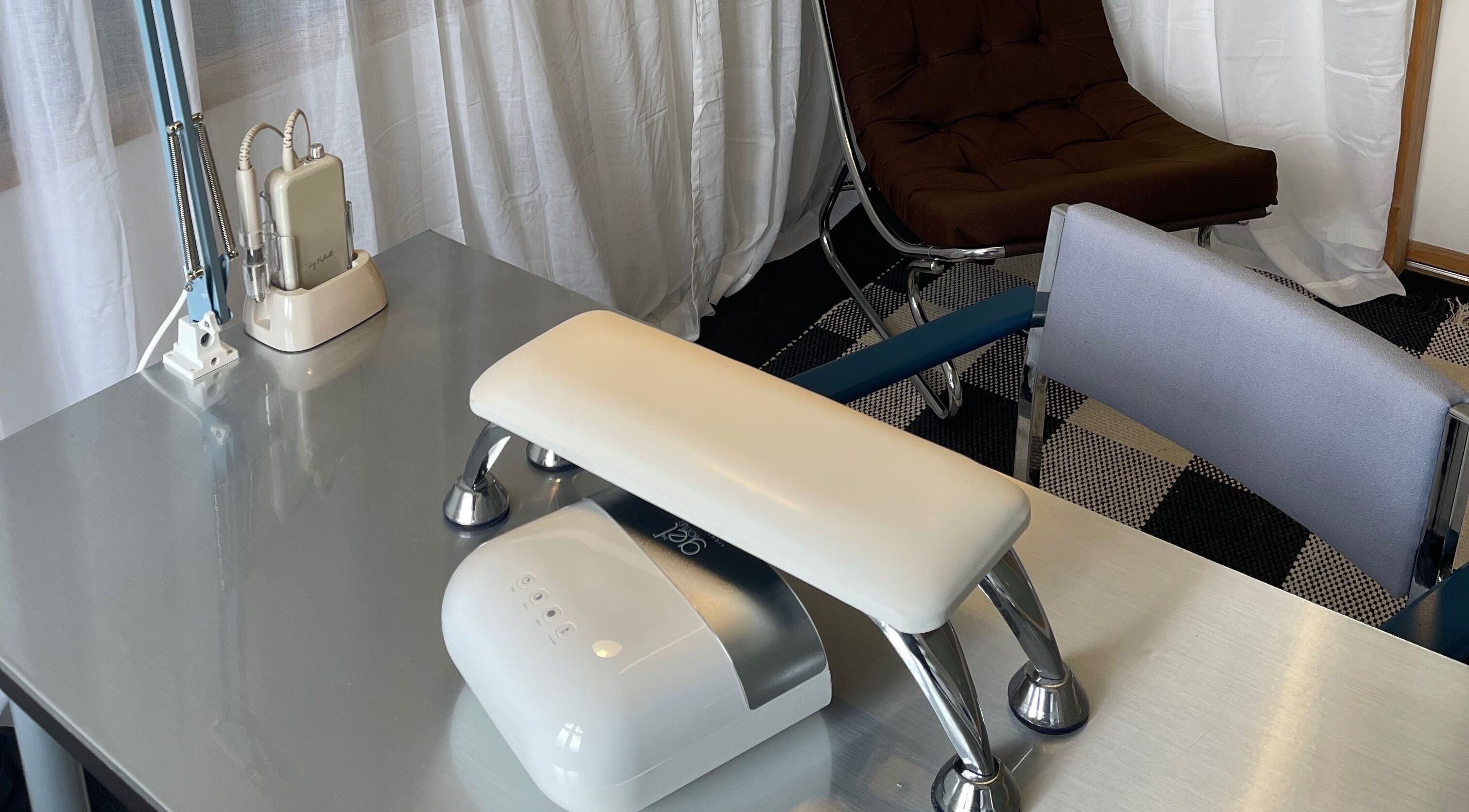 Sleek nail station at Heaps Good Nails, London, England, GB, showcasing modern manicure equipment and seating.