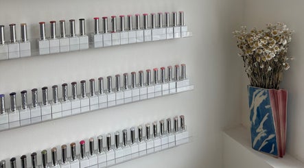 Vibrant nail polish display at Heaps Good Nails, London, England, GB, with dried flowers in a vase.