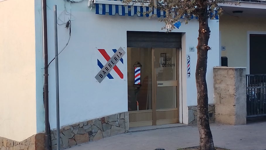 Ingresso di Uccio il barbiere a Ottana, Sardegna, IT con insegne tradizionali.