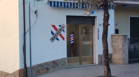 Ingresso di Uccio il barbiere a Ottana, Sardegna, IT con insegne tradizionali.