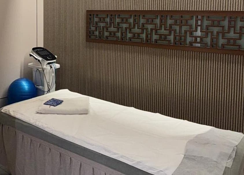 Treatment room at TCM Acupuncture Therapy Center, Dubai, AE, featuring a massage bed and equipment for wellness.