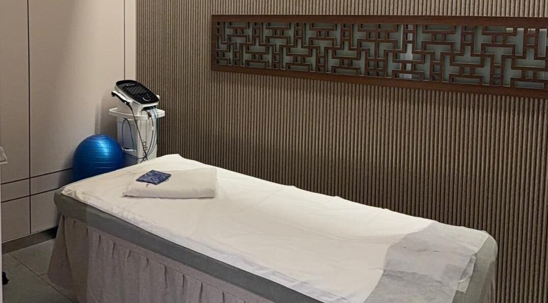 Treatment room at TCM Acupuncture Therapy Center, Dubai, AE, featuring a massage bed and equipment for wellness.