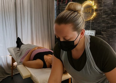 Therapist giving a relaxing massage at Clarity Skin Therapy and Aesthetics, Belfast, Northern Ireland, GB.
