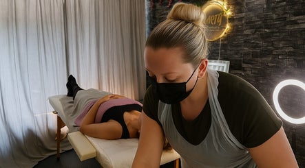 Therapist giving a relaxing massage at Clarity Skin Therapy and Aesthetics, Belfast, Northern Ireland, GB.