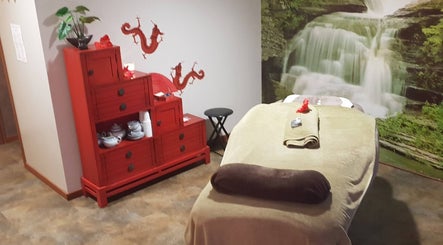 Salle de massage apaisante à Total Zen, Ergué-gabéric, Bretagne, FR avec décor dragon et cascade.