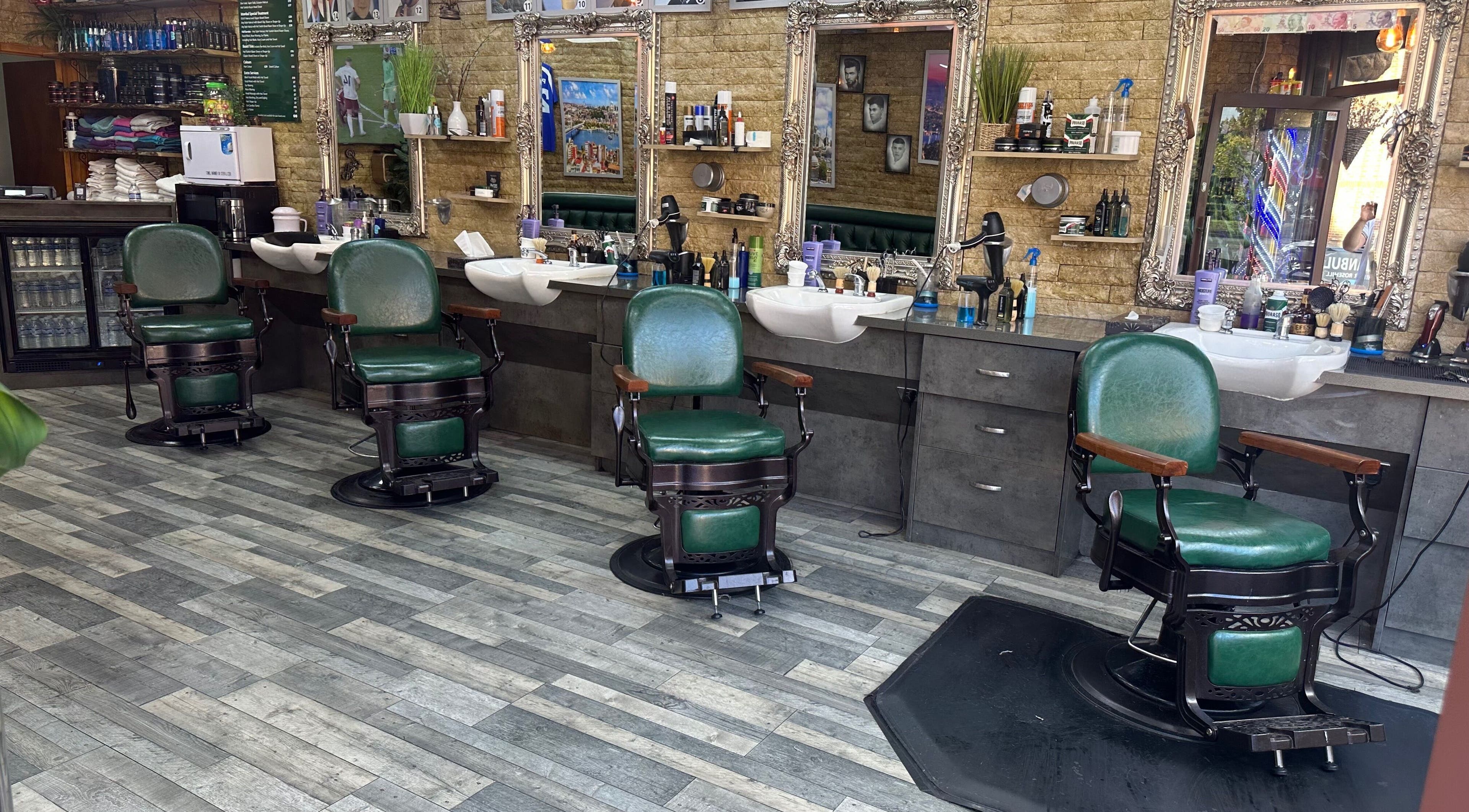Interior of Istanbul Barber Rosehill, Sutton, England, featuring vintage green barber chairs and mirrored stations.