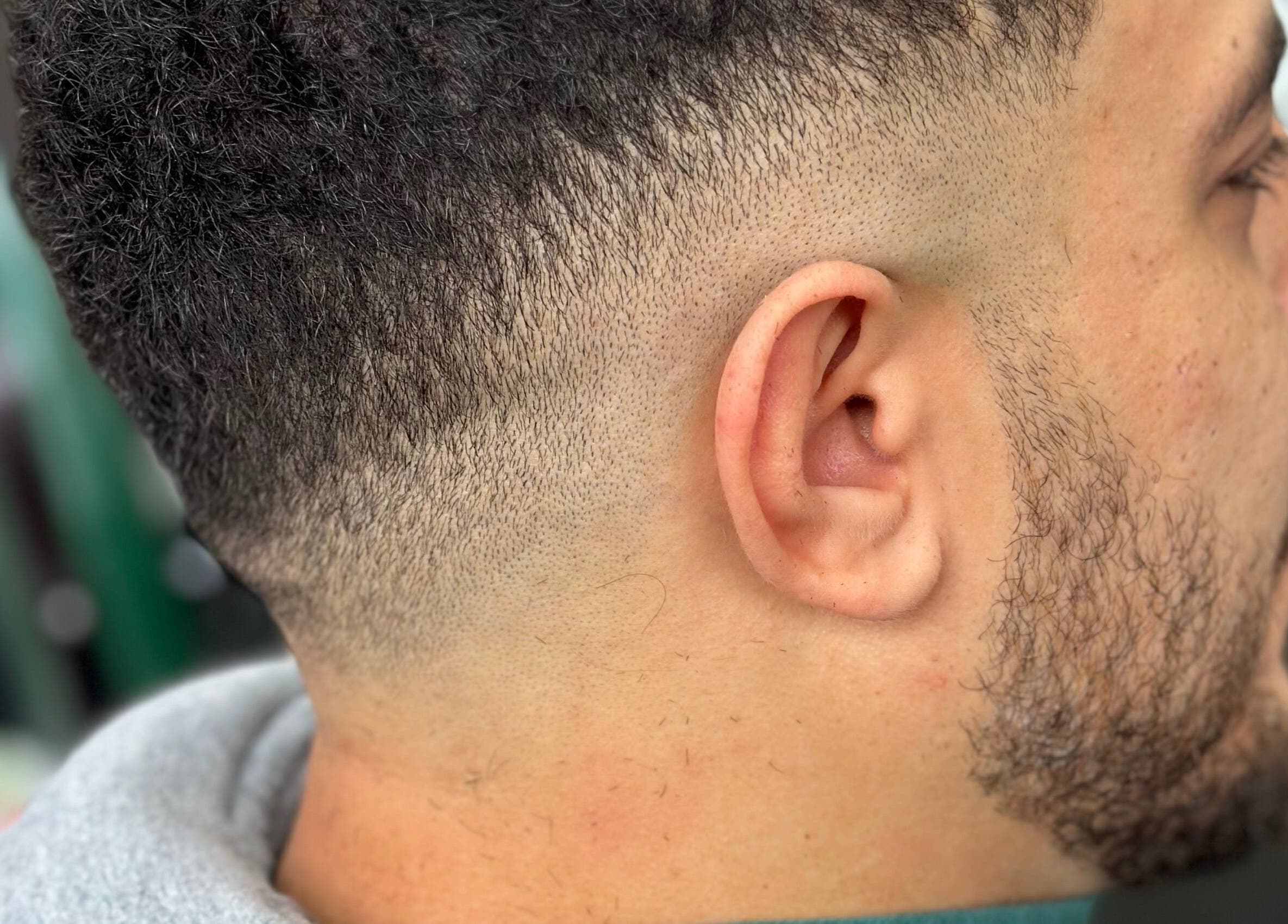 Precision fade haircut at Istanbul Barber Rosehill, Sutton, England, GB showcasing a stylish side profile.