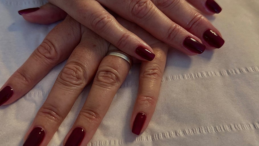 Deep red manicure at The Lush Lounge, Midhurst, England, GB, showcasing elegance and style on well-groomed nails.