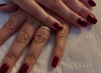 Deep red manicure at The Lush Lounge, Midhurst, England, GB, showcasing elegance and style on well-groomed nails.