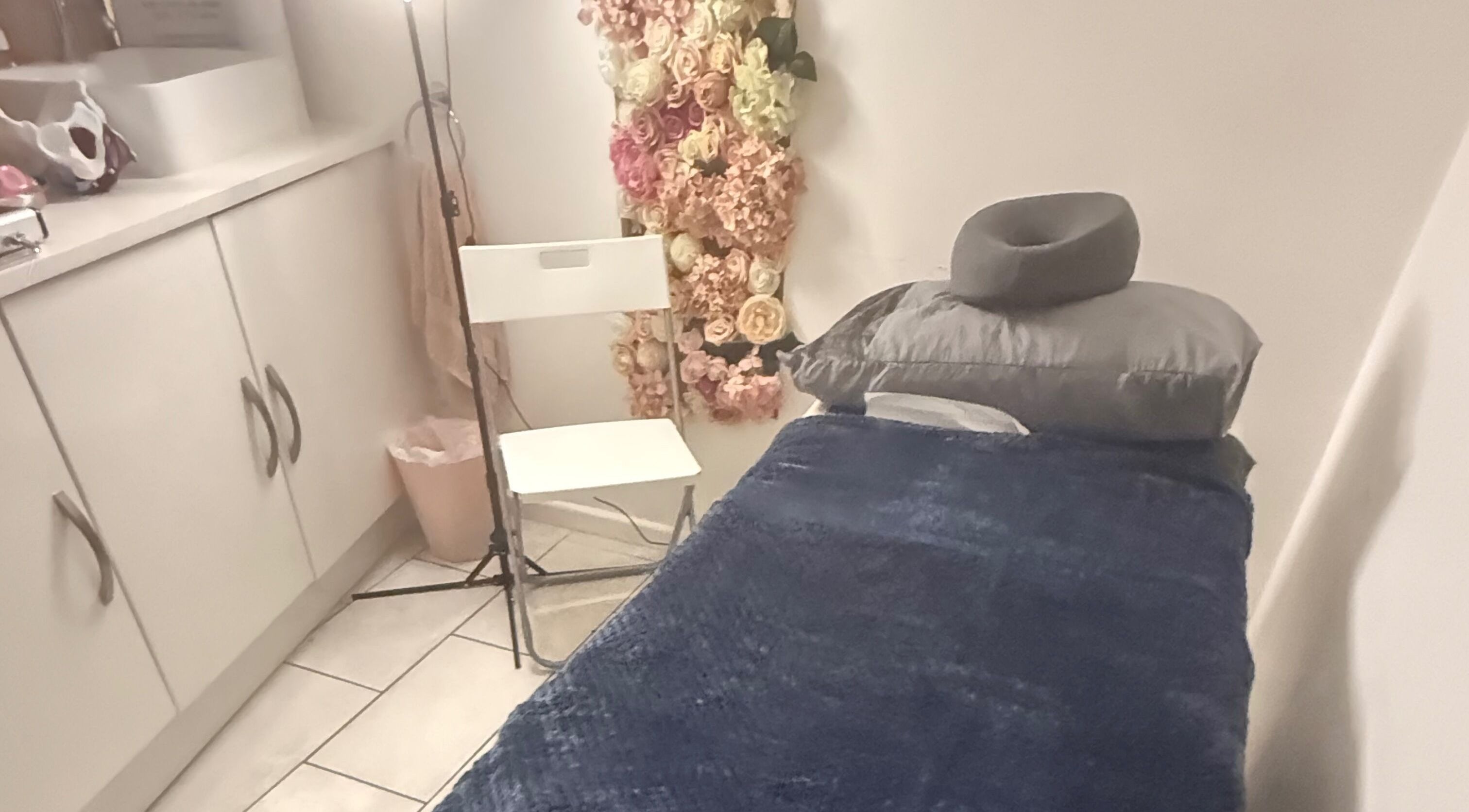 Therapy room at LJW Physio & Pelvic Health, Billericay, England, GB featuring a massage table and floral decor.
