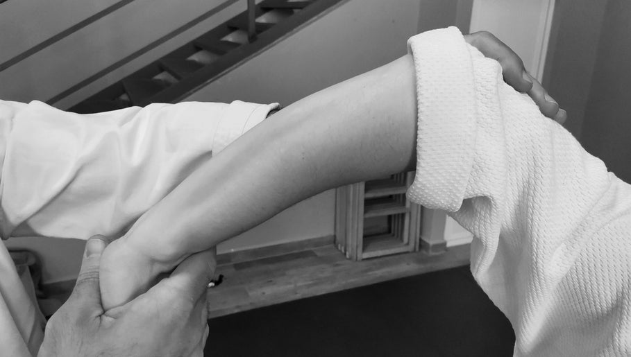 Técnica de relajación del brazo en Masajes DAIKAN DOJO, Málaga, Andalucía, ES, mostrando atención plena.