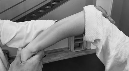 Técnica de relajación del brazo en Masajes DAIKAN DOJO, Málaga, Andalucía, ES, mostrando atención plena.