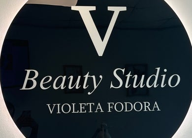Logo Beauty Studio V, Novi Sad, Vojvodina, RS, prikazan na sjajnoj crnoj površini.