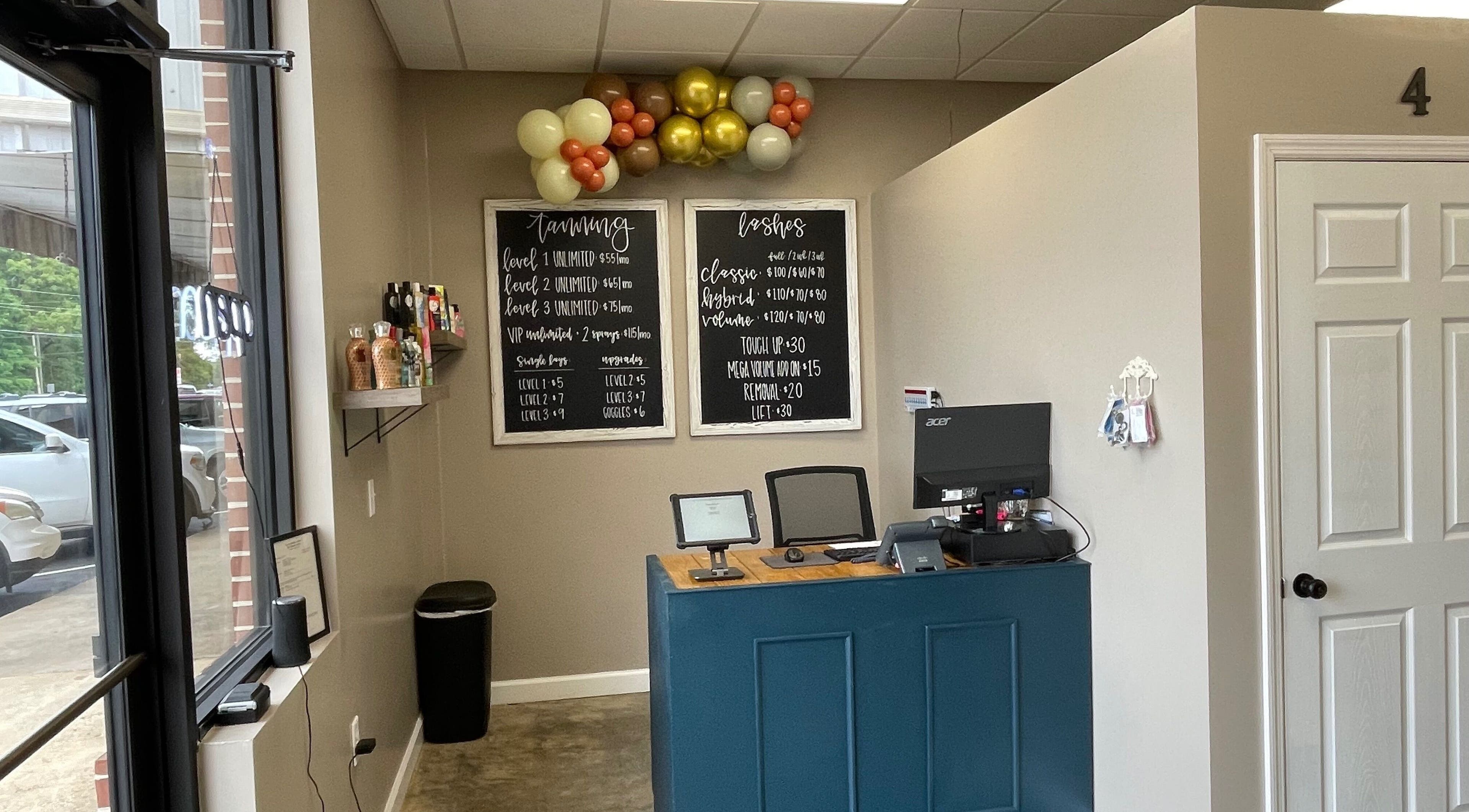 Reception area at Ready Set Glow Tanning LLC, La Fayette, Alabama, US, with price lists and decor.