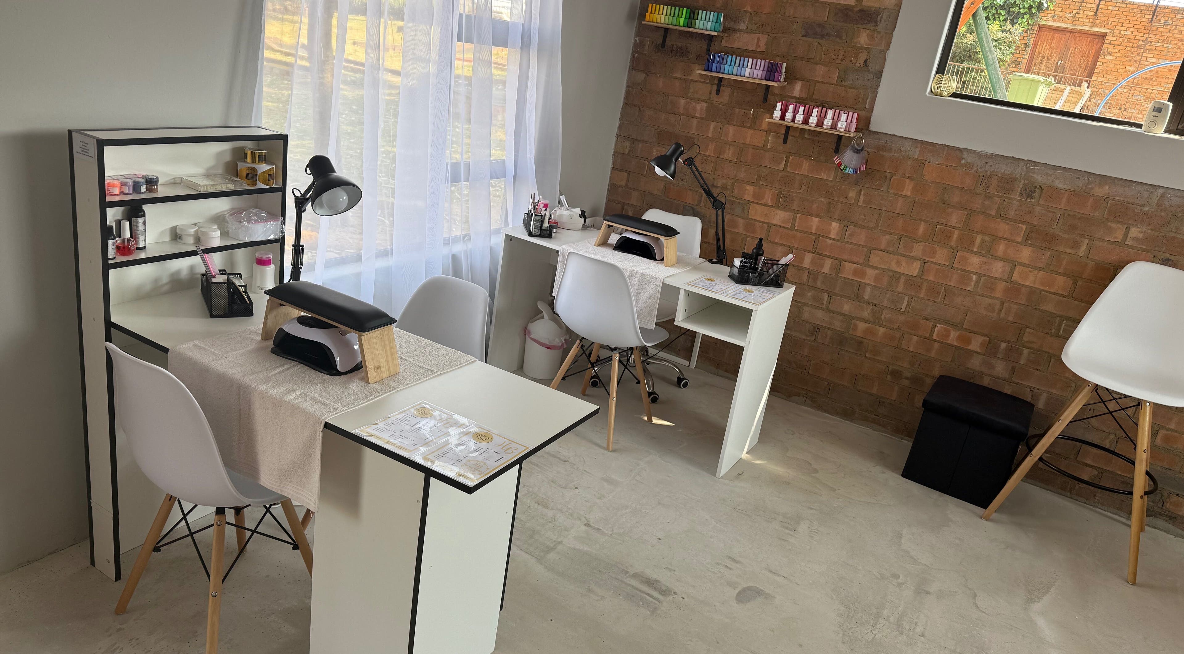 Elegant nail stations at Honey Blush Beauty, Middelburg, Mpumalanga, ZA, showcasing tools and cozy seating.