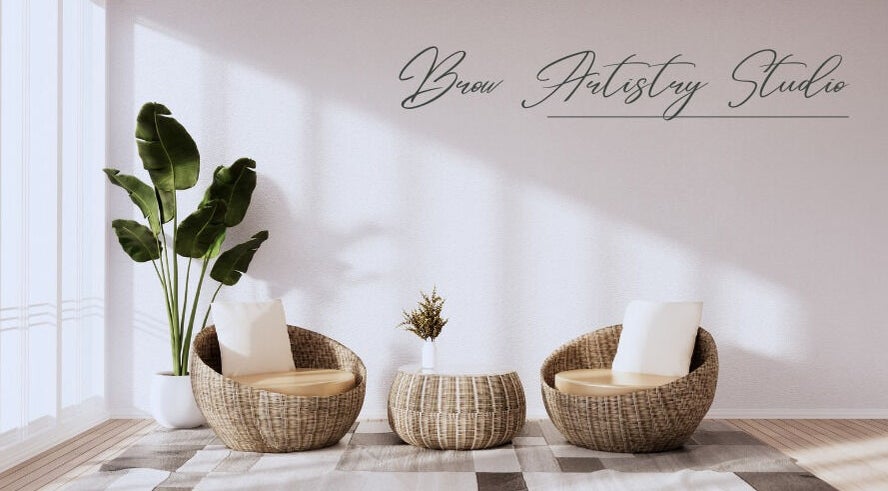 Relaxing seating area at Brow Artistry Studio in Anaheim, California, US with natural wicker chairs and greenery.