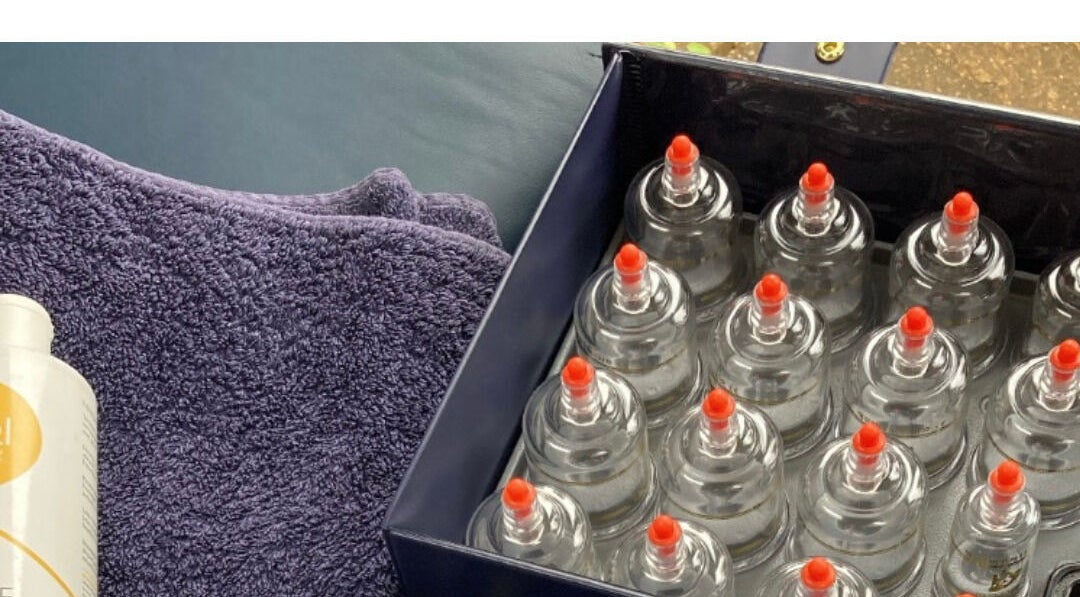 Cupping therapy set at LH Sport Therapy, Mumbles, Newton, Wales, GB with purple towel and oil bottle.