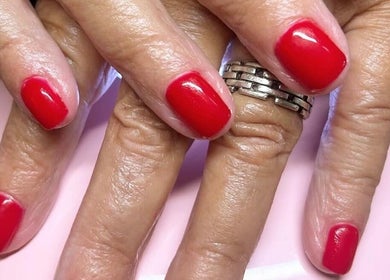 Red manicured nails at Rose Dipped Nails in Southampton, England, GB. Beautiful and vibrant nail art.